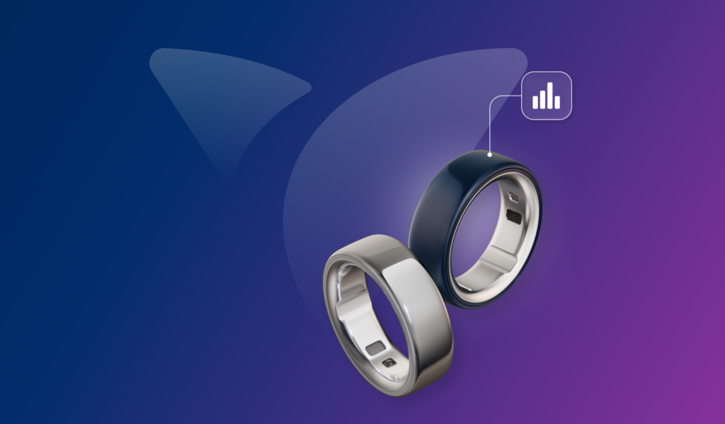 Two sleek smart rings—Oura Ring devices in silver and dark blue—float against a purple-to-blue gradient background, alongside the Vida Health logo, with a small analytics icon suggesting health and activity tracking.